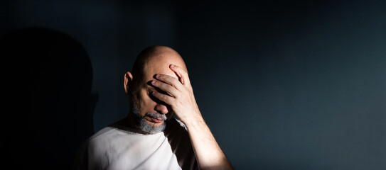 Sad man suffering from headache or migraine. Stressed guy with painful facial expression feeling terrible weakness or depression.