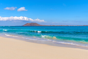 Fototapeta na wymiar View on Corralejo beach and Lobos island, blue water and golden sand and the Canary Island Fuerteventura, Spain.