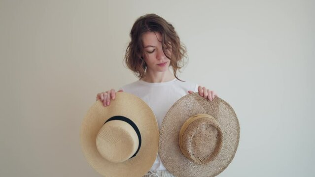 Young woman on vacation chooses a hat to match her outfit