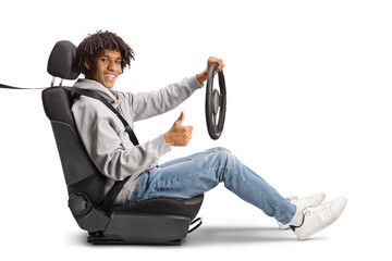 Casual african american young man holding a steering wheel and gesturing thumbs up