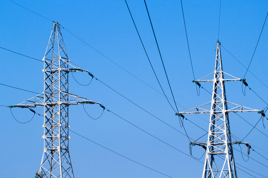 Transmission towers over blue sky background