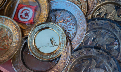 Fototapeta na wymiar Djerba, Tunisia - April 4, 2023: Souvenirs from vacation in Tunisia. Tunisian handicrafts, metal plates with engraved illustrations.