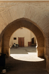 Moorish arch. entrance doors and a motorcycle in the streets of the Medina in Marrakech