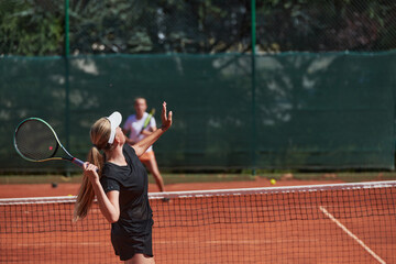 Young girls in a lively tennis match on a sunny day, demonstrating their skills and enthusiasm on a modern tennis court.