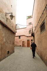 Fototapeta na wymiar Man walking in the Marrakech Medina of Morocco