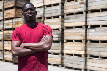 Portrait of confident afro american with arms crossed at warehouse of fruit packing factory