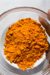 Cheddar cheese powder in a glass bowl, orange cheese power, dehydrated cheddar cheese for making cheese popcorn