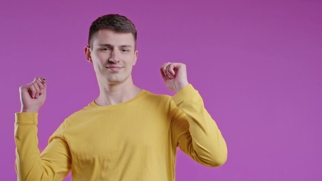 Active positive young man dancing on pink background. Funny dance,good mood, day