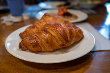 Two fresh baked puff croissants, traditional French breakfast