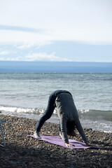Elderly woman practices yoga alone, in front of Lake Buenos Aires, in Los Antigos, Argentine...