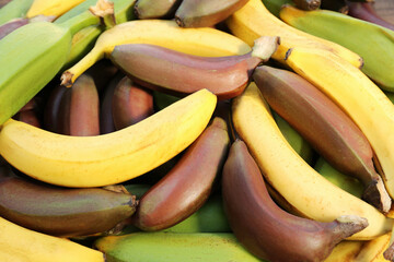 Different types of bananas as background, top view