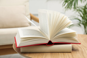 Different hardcover books on wooden table indoors