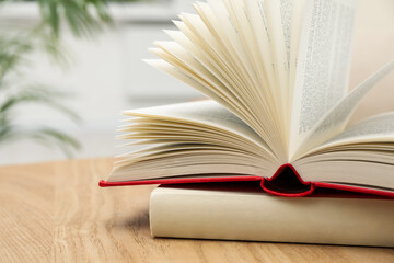 Different hardcover books on wooden table indoors, closeup. Space for text