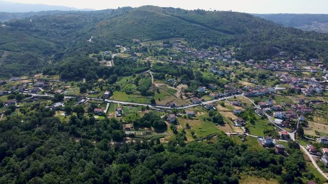 Calm peaceful countryside town along valley road in forested valley, aerial