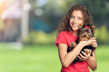 Happy young woman with cute dog in the park