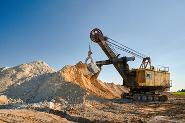 Shovel mining excavator operates in large open chalk quarry - obrazy, fototapety, plakaty