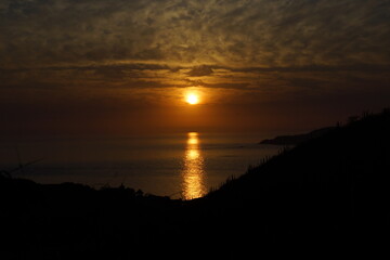 Sol resplandeciendo sobre el mar durante el atardecer