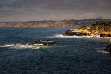 Fototapeta na wymiar 2022-08-17 LA JOLLA SHORELINE WITH ANICE SKY AND A ROCK WITH CORMORANTS RESTING ON IT AND LA JOLLA SHORES IN THE DISTANCE