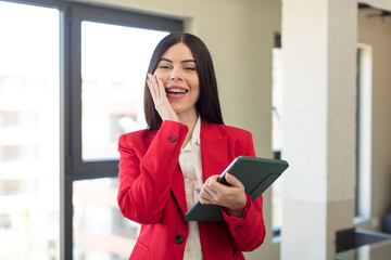 pretty young woman feeling happy and astonished at something unbelievable. touch screen pad concept