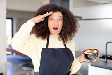 pretty afro black woman looking happy, astonished and surprised. japanese noodles ramen concept