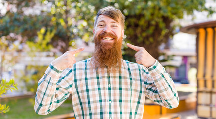 red hair bearded man smiling confidently pointing to own broad smile, positive, relaxed, satisfied...