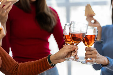 Three beautiful white women housemates with glasses of white wine are having fun celebrating and drinking on a summer day on a real vacation.