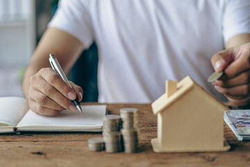 Saving money and putting coins in a piggy bank on the table for monthly payments Paying bills or inflation with a savings plan