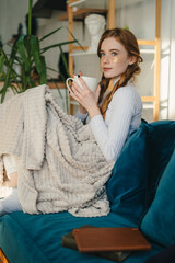 Photo portrait of red-haired positive single woman having free time sitting on divan covered in a...