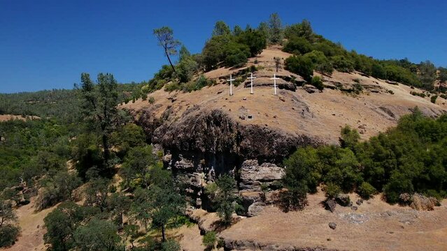 Aerial cinematic drone calvary cross Richard Springs YWAM Chico California Upper Bidwell Park butte cave creek canyon three cross on hillside crucifixion place of skull mid day sunny forward motion