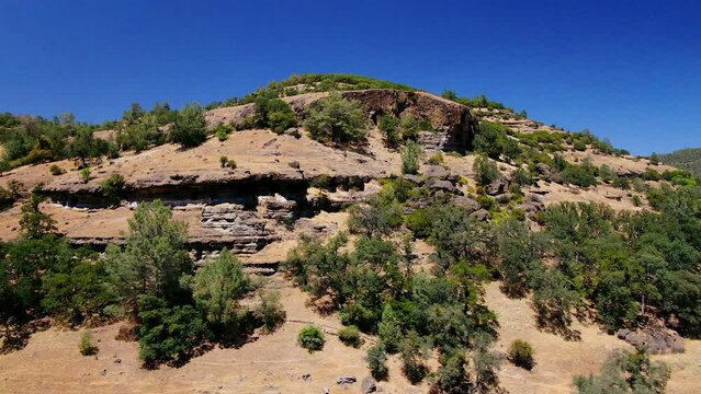 Aerial cinematic drone calvary cross Richard Springs YWAM Chico California Upper Bidwell Park butte cave creek canyon mid day sunny circling motion to the right