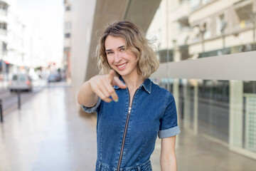 Fototapeta premium pretty woman pointing at camera with a satisfied, confident, friendly smile, choosing you
