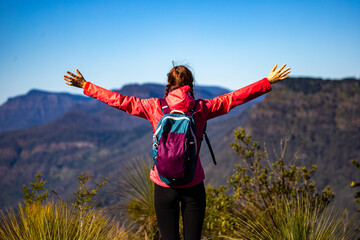 A backpacker girl enjoys the view from the top of Mount Mitchell after a successful hike, Main Range National Park, Gold, Coast, Queensland, Australia
