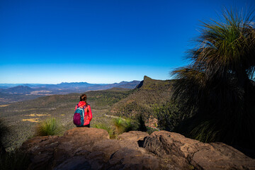 A girl with a backpack enjoys the view of Mount Mitchell from the top of Mount Cordeaux, Main Range National Park, Gold Coast, Queensland, Australia