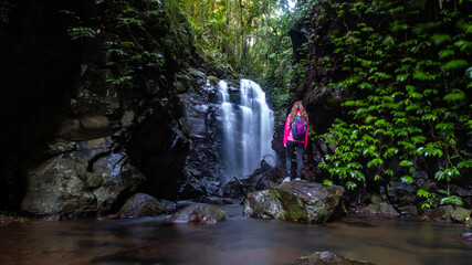 Hiker girl admires stunning  Box Log Falls hidden in a canyon in Lamington National Park,...