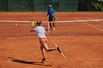 A professional tennis player and her coach training on a sunny day at the tennis court. Training and preparation of a professional tennis player