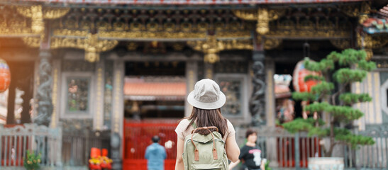 Fototapeta na wymiar woman traveler visiting in Taiwan, Tourist with hat sightseeing in Longshan Temple, Chinese folk religious temple in Wanhua District, Taipei City. landmark and popular. Travel and Vacation concept