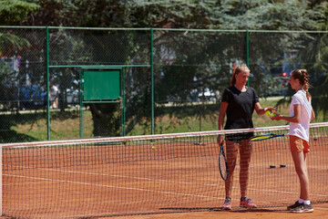 Tennis players standing together on the tennis court, poised and focused, preparing for the start of their match