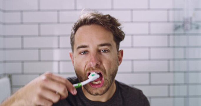 Mirror, cleaning and man brushing teeth, bathroom and morning routine with oral hygiene, wellness and grooming. Male person, reflection and guy dental hygiene for his mouth, toothbrush and self care
