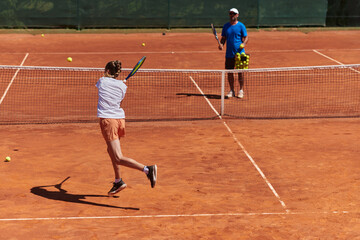 A professional tennis player and her coach training on a sunny day at the tennis court. Training and preparation of a professional tennis player