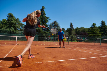 Obraz premium A professional tennis player and her coach training on a sunny day at the tennis court. Training and preparation of a professional tennis player