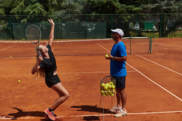 A professional tennis player and her coach training on a sunny day at the tennis court. Training...