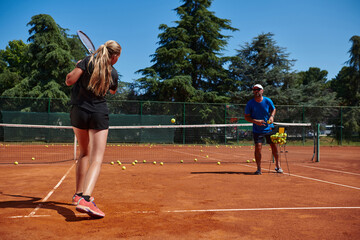 Obraz premium A professional tennis player and her coach training on a sunny day at the tennis court. Training and preparation of a professional tennis player