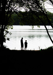 Fototapeta na wymiar Father and son looking at a gigantic and beautiful lake that they found together on Father's Day