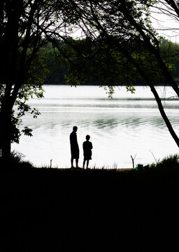 Father and son looking at a gigantic and beautiful lake that they found together on Father's Day