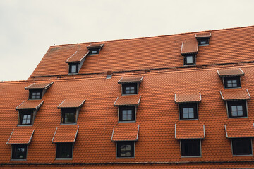 Corner with dormers Red Roofs of the city brown metal tiles roof of European house with windows....