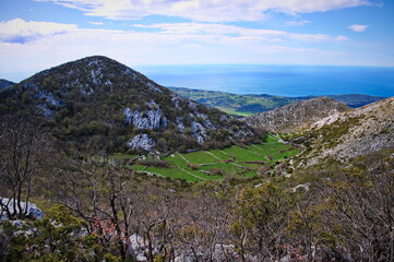 Naklejka premium Field in the valley surrounded with karst hills