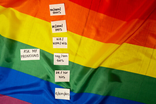 ASK MY PRONOUN Neo pronouns concept. Rainbow flag with paper notes text gender pronouns hie, e, ne, xe, ze, tey. Non-binary people rights transgenders. Lgbtq community support assume my gender