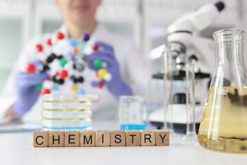 Word Chemistry against lab assistant showing molecule model