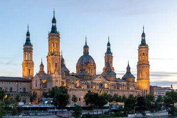 Fototapeta na wymiar Zaragoza, Spain - May 01, 2023: ebro river, in front of the Basilica del Pilar, with very low water level due to drought and climate change in Zaragoza, Spain