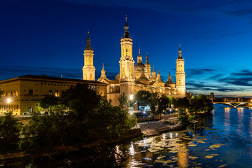 Fototapeta na wymiar Zaragoza, Spain - May 01, 2023: ebro river, in front of the Basilica del Pilar, with very low water level due to drought and climate change in Zaragoza, Spain